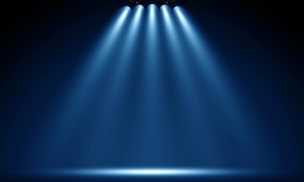 The Wisdom of Ritual Mockery: How Traditional Societies Use Sacred Satire for Social Healing spotlights illuminate empty stage